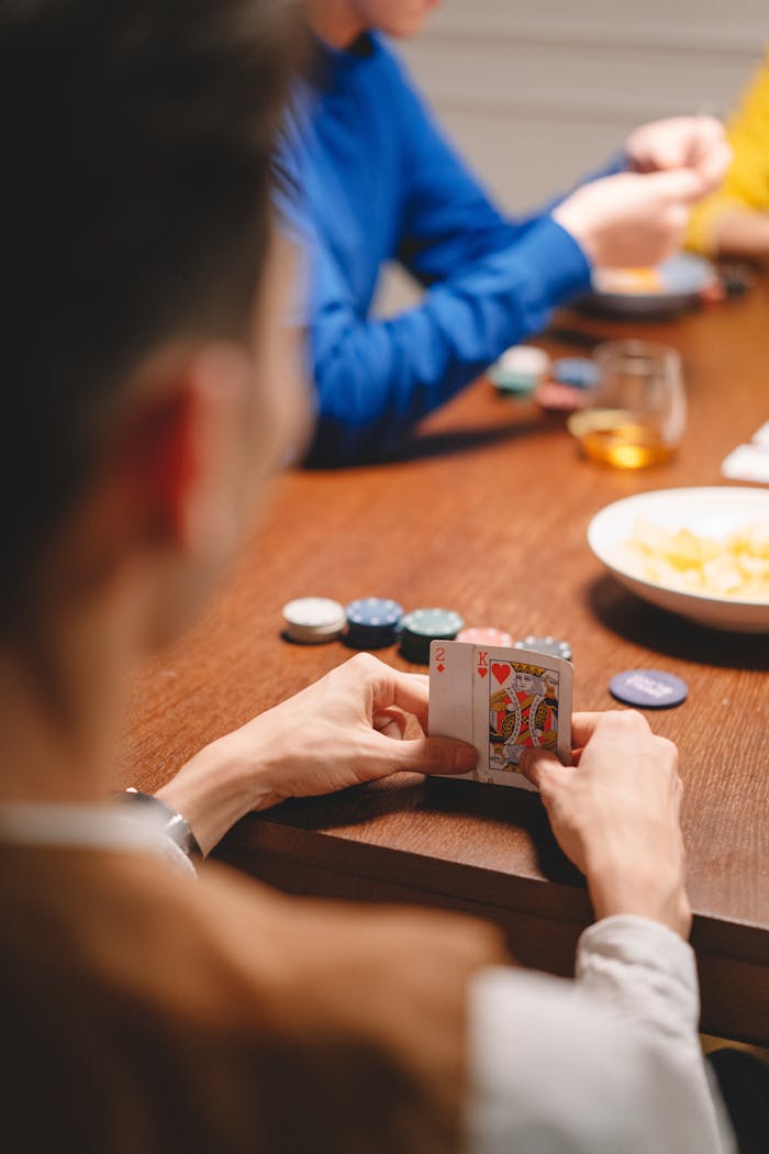 A group of adults enjoying a game of poker at home, showcasing strategy and excitement.